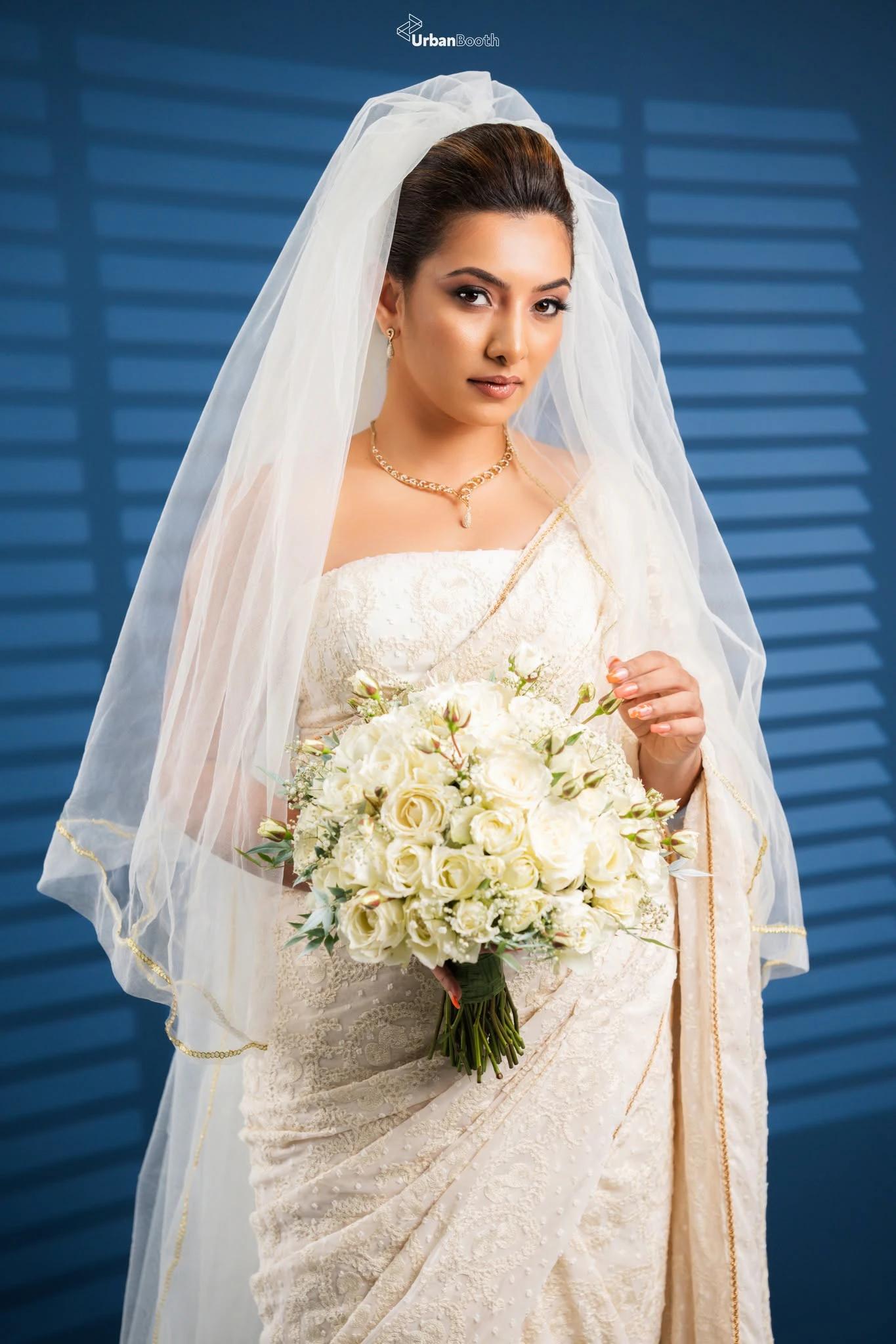 Bridal portrait with white flowers and a blue backdrop